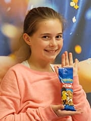 Grace holding a packet of peanuts