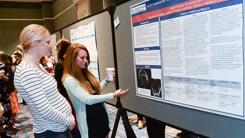 Cardiology 2020 presenter pointing to research poster