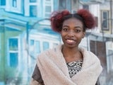 Smiling adolescent with black and red hair and a nose piercing.