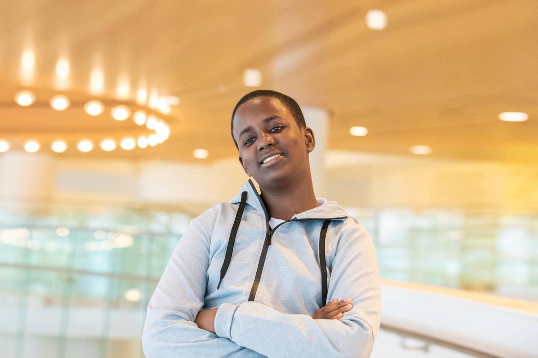 Teen standing with his arms folded