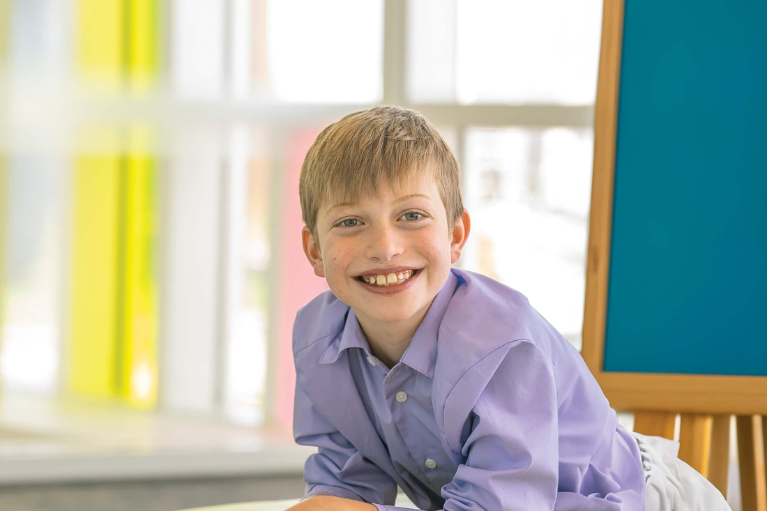 Young teen smiling leaning on ottoman