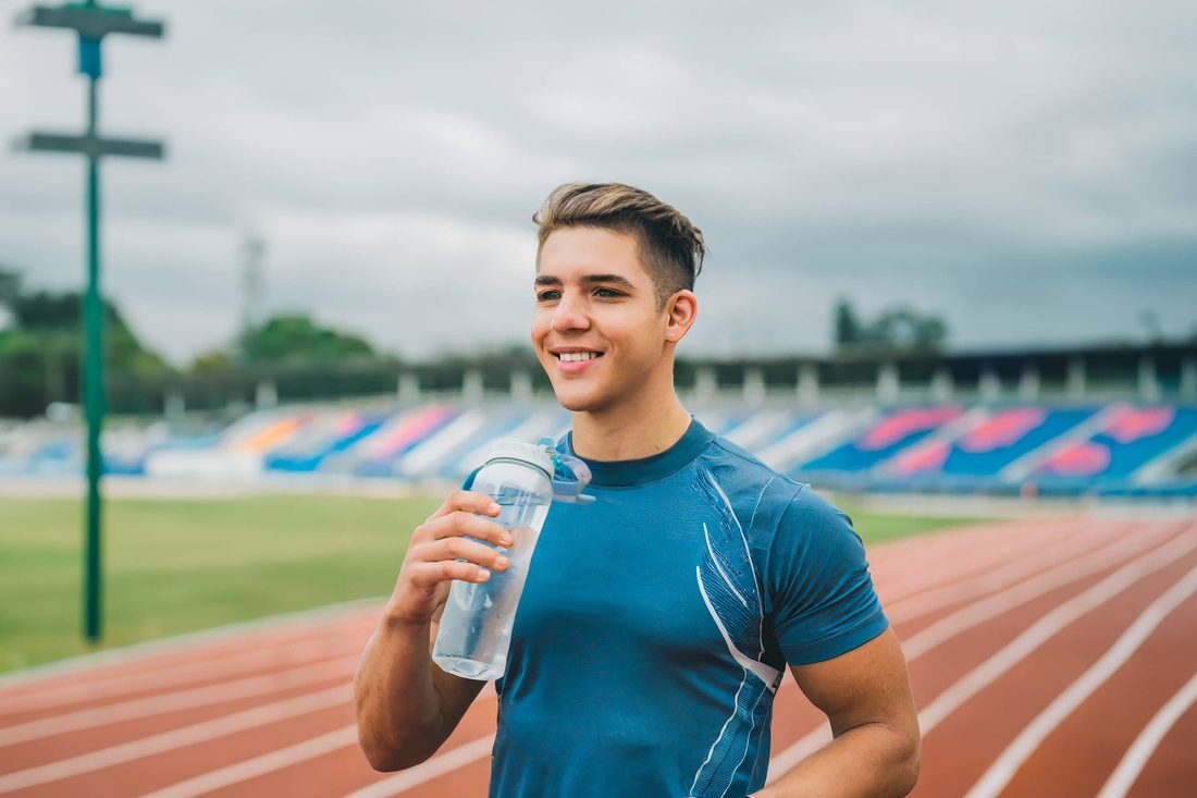 Teen boy drinking water after a run