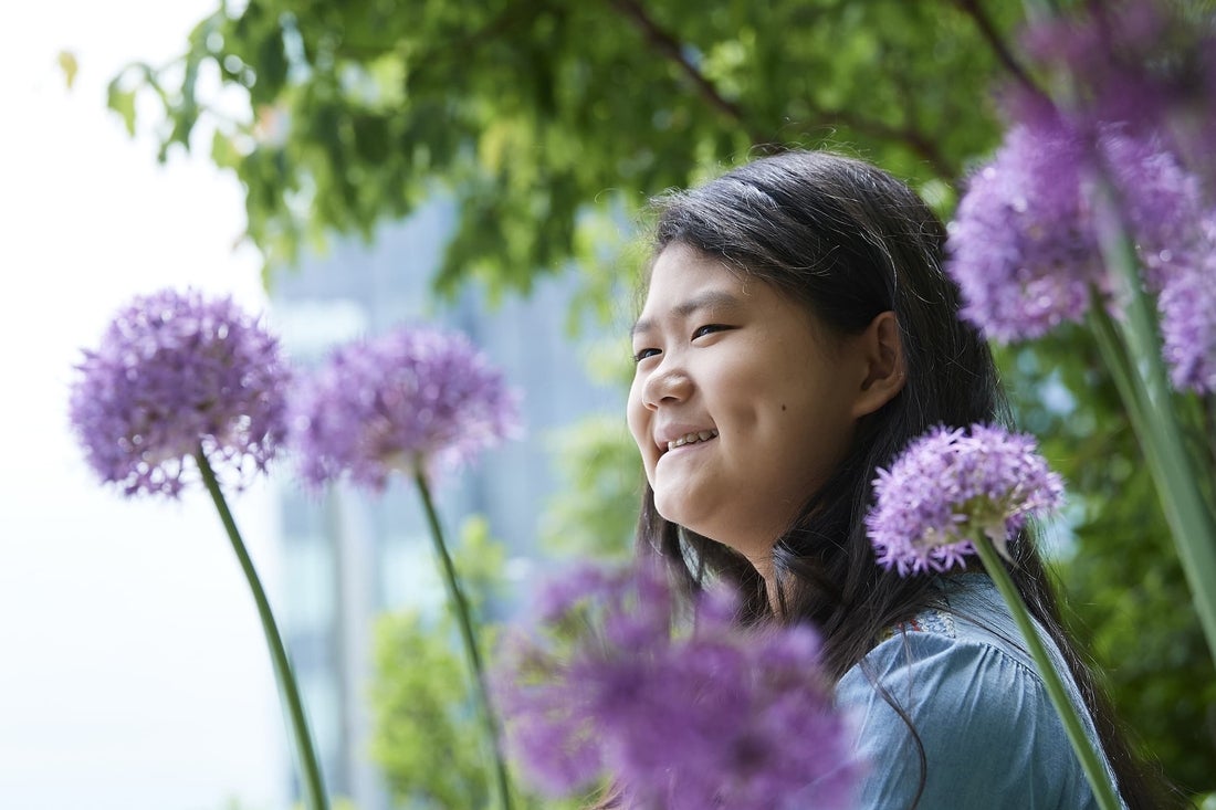 Asian girl smiling with flowers around her