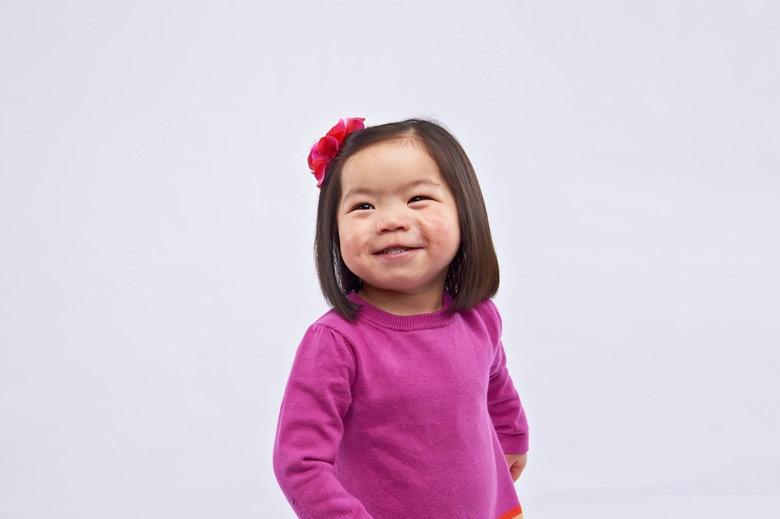 Little girl smiling with a neutral background