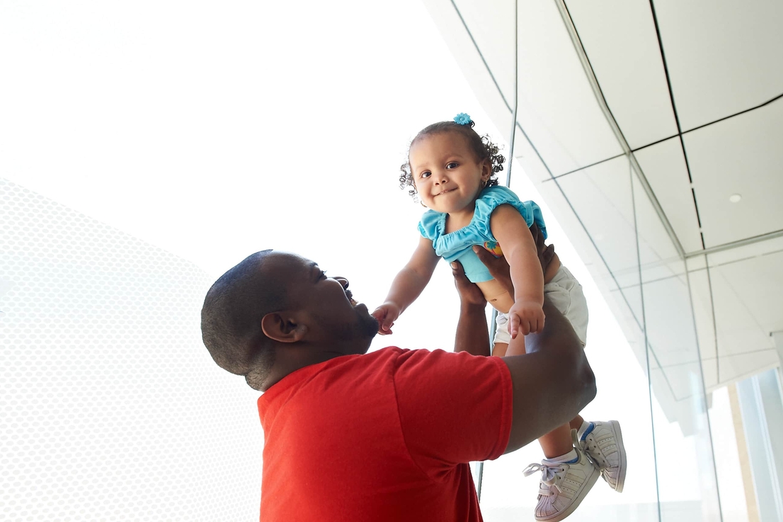 fahter holding up daughter smiling