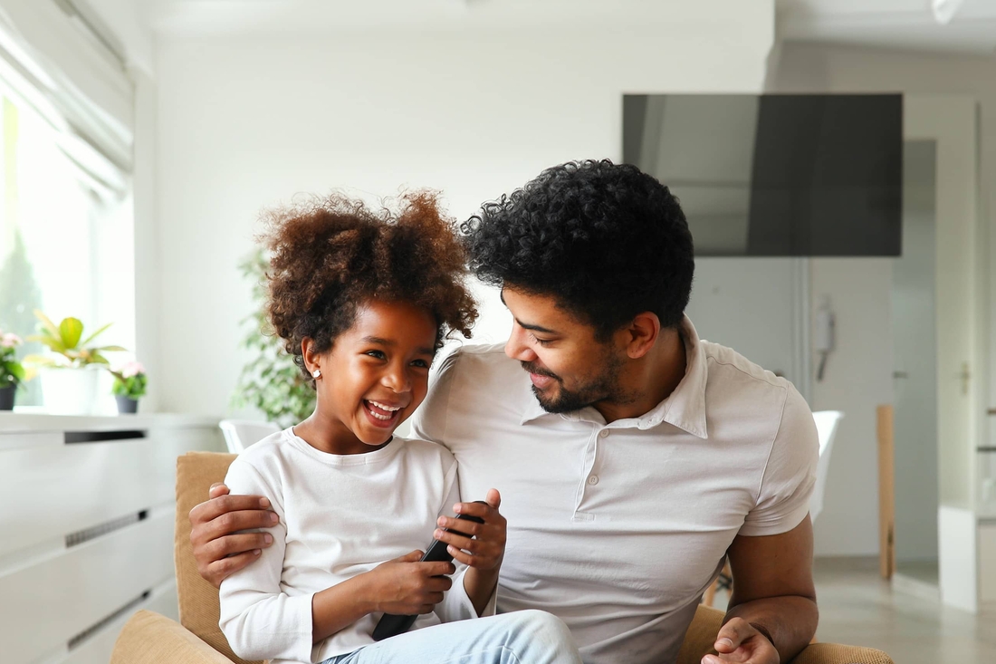 Father and daughter sitting together laughing