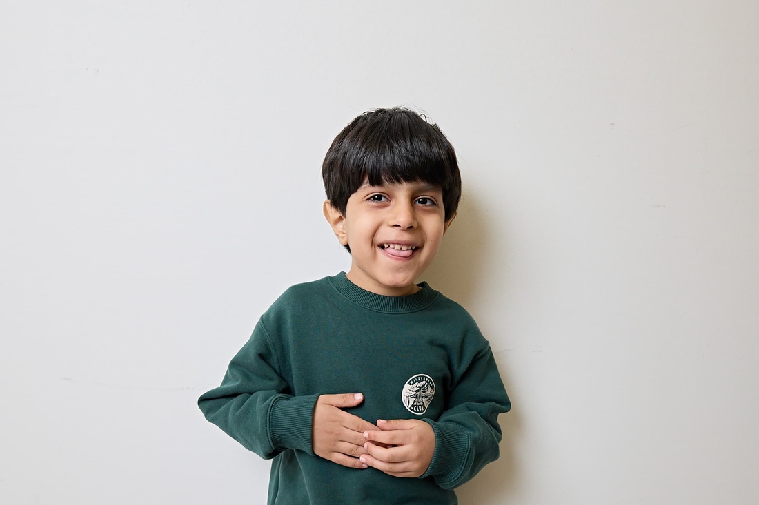 Young boy in green shirt smiling