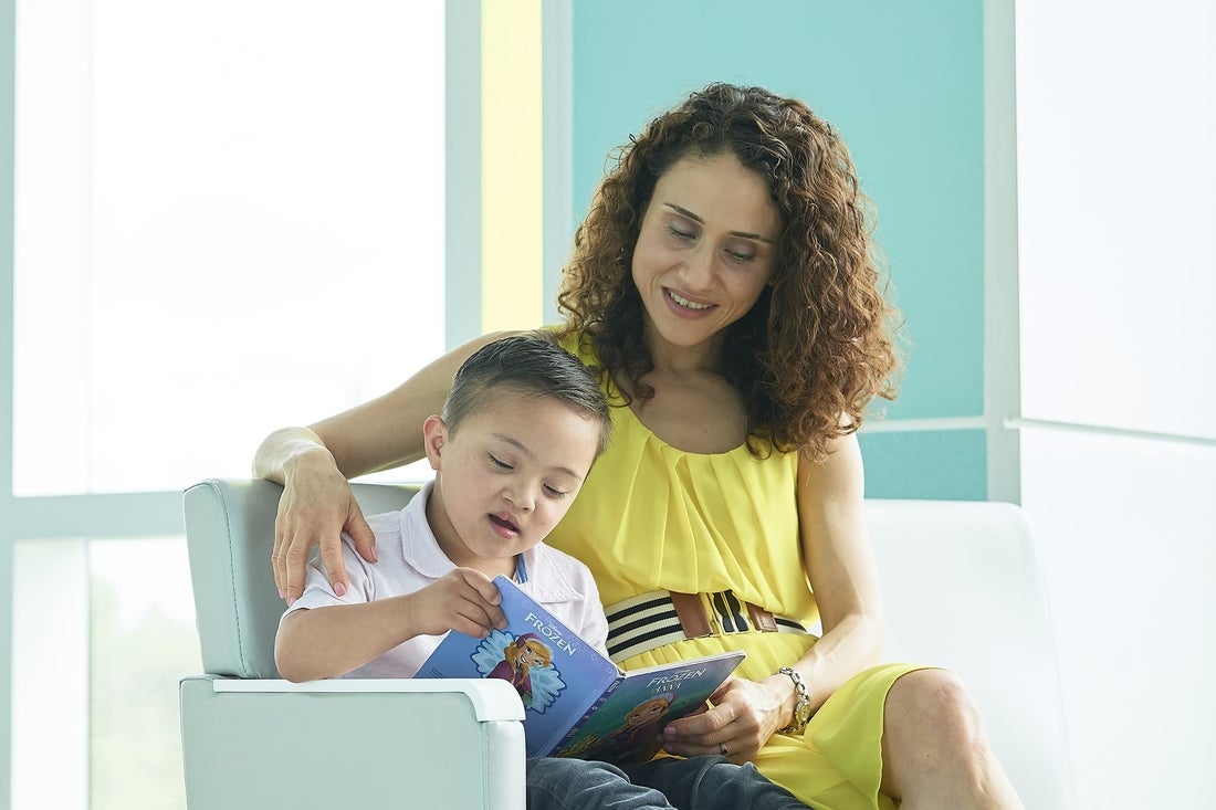 Woman reading book to young boy