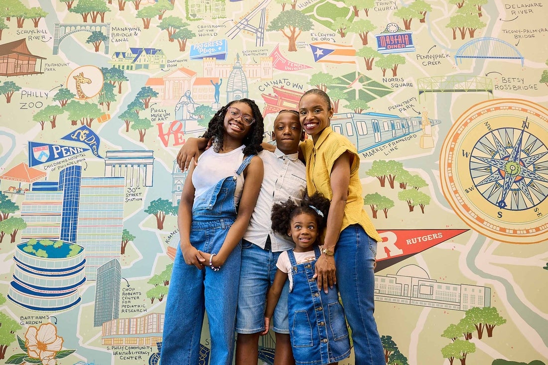 Family of four standing in front of a colorful mural