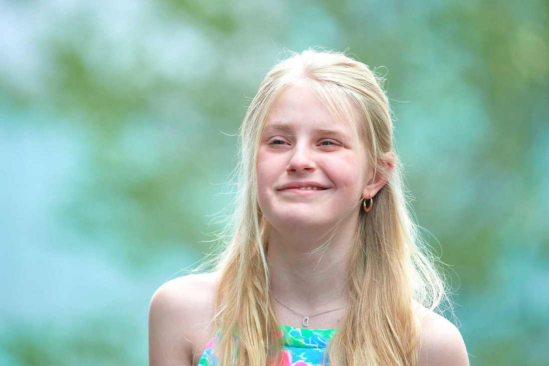 Smiling girl with long blond hair and colorful top