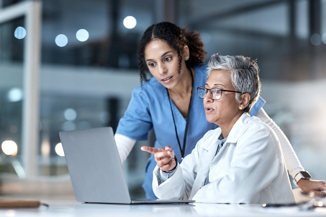 Two healthcare providers looking at laptop 