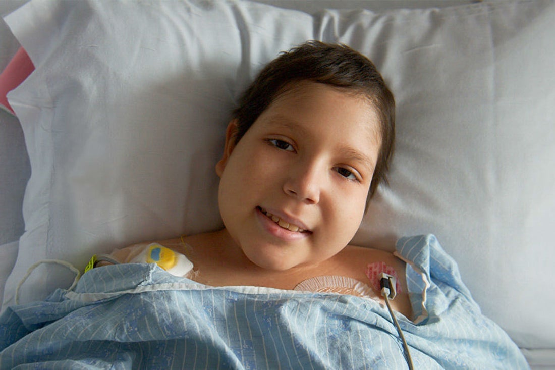 child in hospital bed smiling