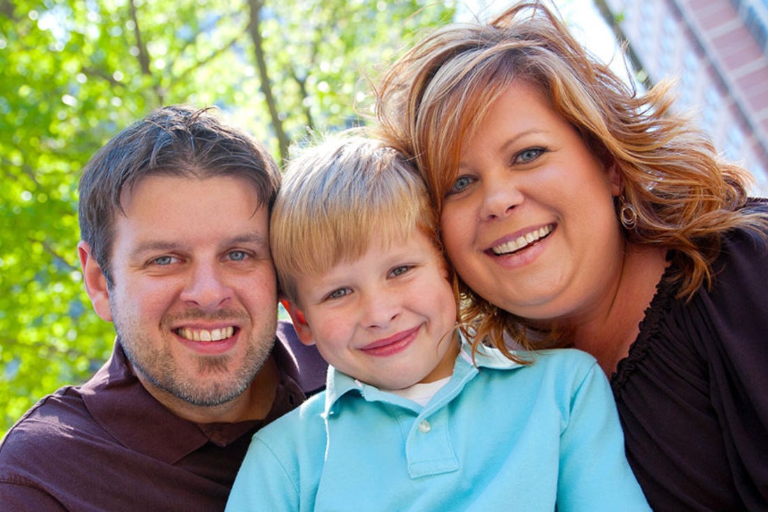 Mom and dad pose with their son.