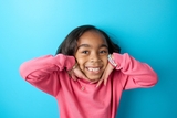 Girl smiling with hands up to her cheeks