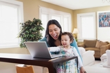 Mother sitting with her child with her computer