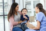 Young boy at a doctor office sitting on his mothers lap