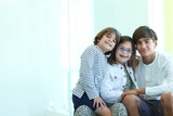 Three siblings hugging, Trisomy 21 girl is wearing glasses