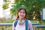 Teen girl standing outside wearing headphones