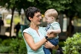 Pediatric female doctor and blonde boy smiling at each other in the hospital garden