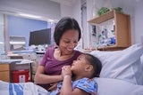 Mother comforting her daughter in her hospital bed