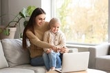 Mom and daughter with cancer looking at resources on laptop.