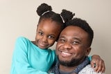 Father hugging his daughter and smiling