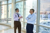 two physiciands discussing treatment in a hallway