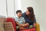 Patient with glasses and a therapist sharing a chair