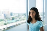 Young teen standing in front of the window smailing