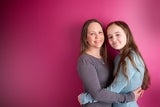 Teen girl and her mom hugging and holding one another.