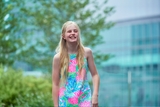 Blonde girl in floral dress ouside with craniofacial anomality.