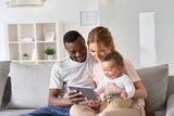 Mother and Father researching their laptop with their baby