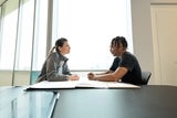 physician and doctor talking at a table