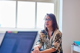 Doctor wearing glasses, sitting in an office