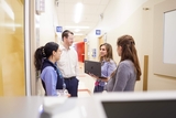 Residents with team leader meeting in hallway.