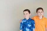 Two brothers, one in blue shirt, one in an orange shirt