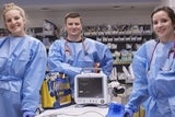 Clinical staff in blue surgical bunny suit in procedure room