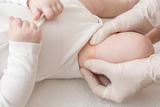 Placing a bandage on baby's leg