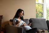 Mom holding baby and looking at cell phone