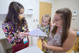 Clinician speaking with mother and child in exam room