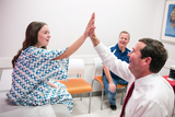 Clinician high fiving a patient in exam room