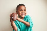 Young boy holding a football and smiling