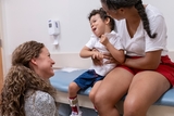 Emma McKenzie, a physical therapist in the Seating Clinic, greets Apollo, 4, who has cerebral palsy, and his mother, Lesana.