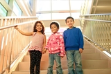 Three kids standing on the stairs in the Karabots Center.