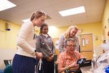 Four nurses at a shelter looking at a computer and phone.