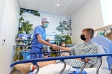 ACL patient Liam shakes hands with his surgeon Dr. Ganley while lying in bed before surgery