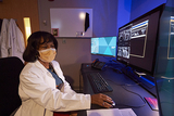 Radiologist Dr. Coleman sits at a computer reviewing prenatal imaging on screen.