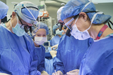 A surgical team in the operating room surrounds a fetal surgery patient