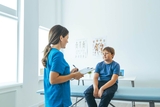 Young teen in exam room with physician