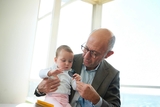 Infant examining a stethoscope with physician